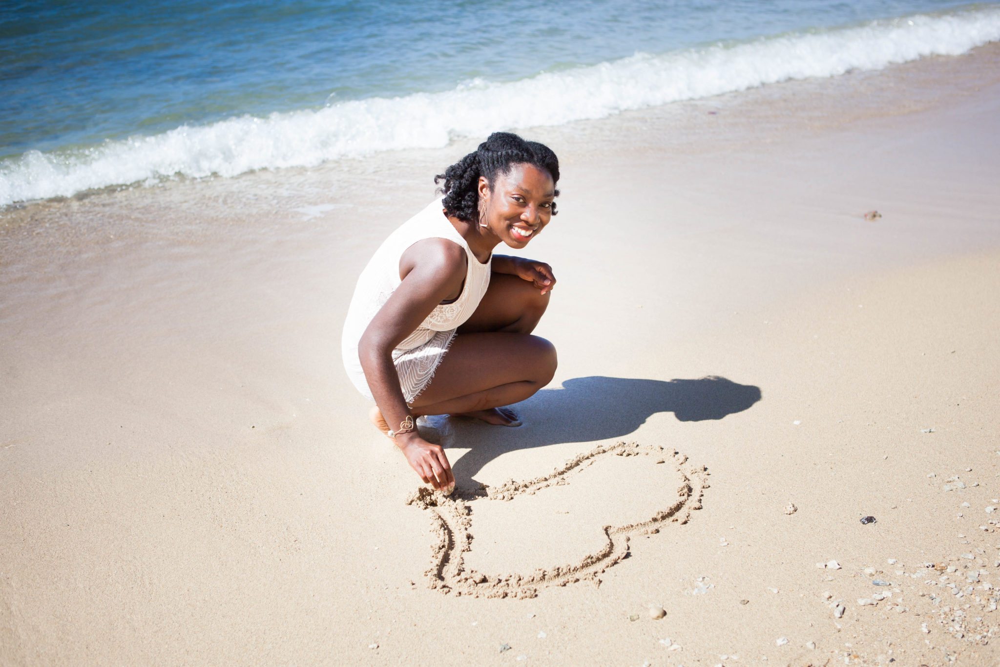Woman drawing heart in sand - Black Love 8 Insights for Mothers Grieving the Loss of a Child