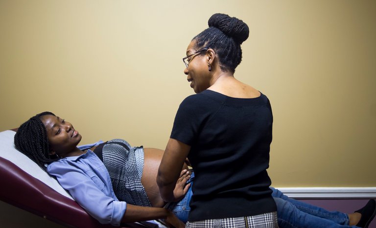 Jennie-pic-at-clinic - Black Love British-born midwife Jennie Joseph with a patient (Photo courtesy of jenniejoseph.com)
