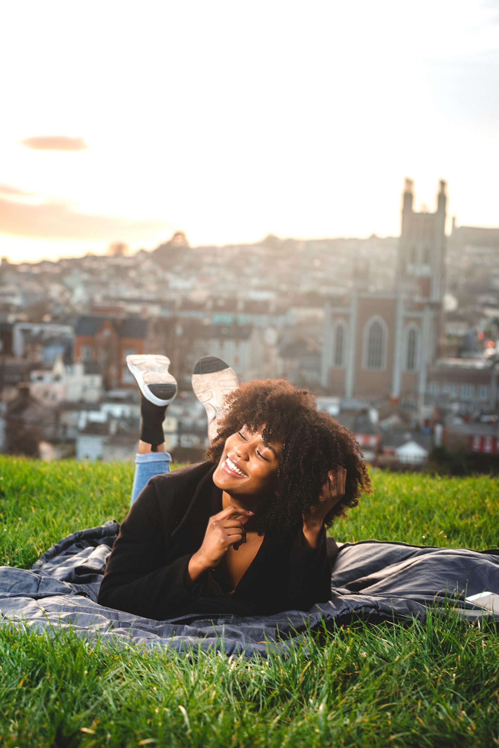 Woman smiling and lying in grass - Black Love Courtesy of Pexels.com