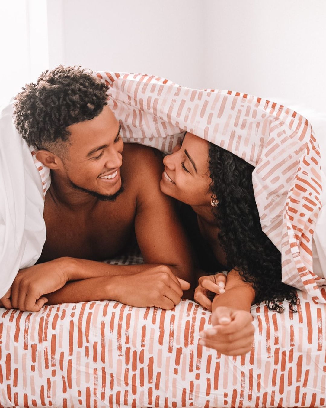 Courtesy of @tenesiaandterence - Black Love Couple under sheets (Courtesy of @tenesiaandterence)