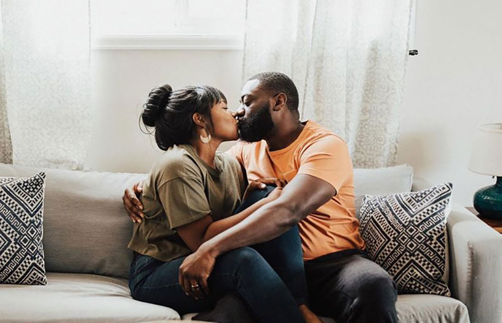 Courtesy of @carmen.bridgewater - Black Love Couple kissing on couch (Courtesy of @carmen.bridgewater)