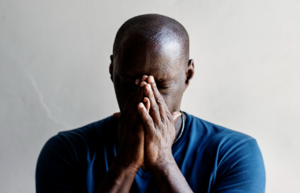 Depressed man with his face in his palms (Courtesy of rawpixel.com)