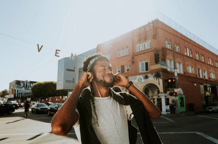 Man smiling while listening to music in Venice (Courtesy of rawpixel.com)