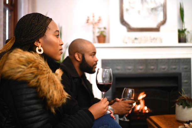 Credit: iStockPhoto - Black Love Couple listening to someone talk near a fireplace