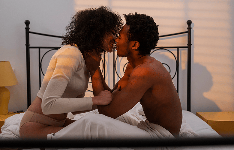 couple kissing in bed - Black Love Navigating Sexual Safety Conversations in a New Relationship