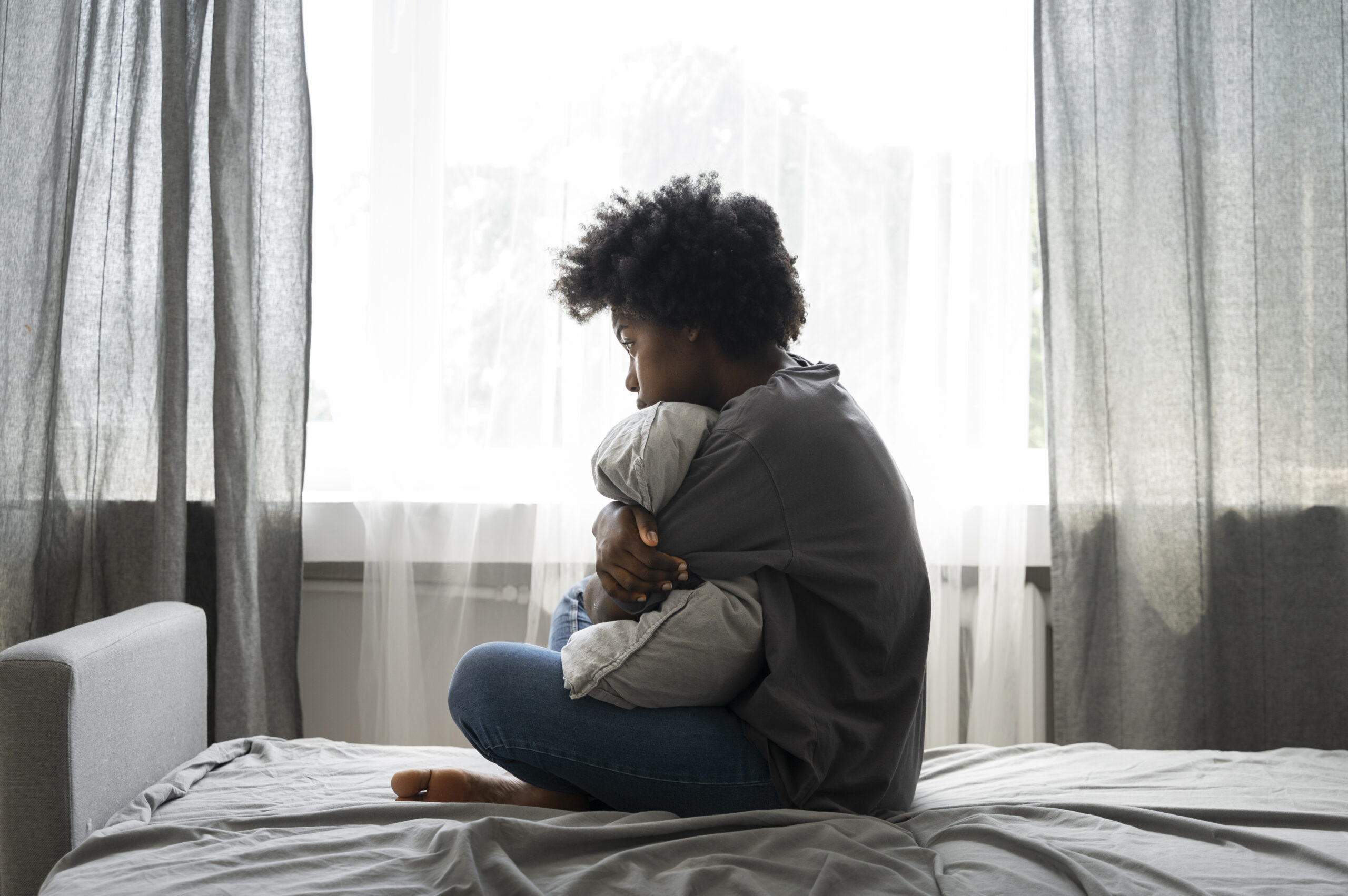 Courtesy of freepik.com - Black Love woman sitting in bed looking sad