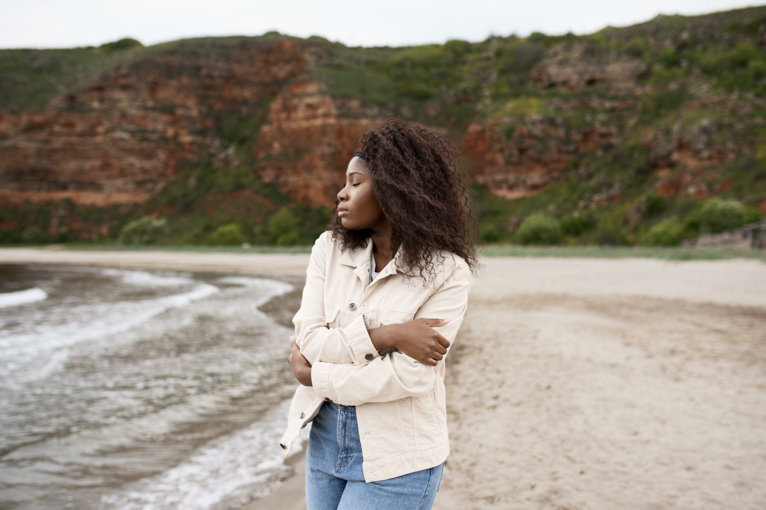 woman holding herself at the beach (Courtesy of freepik.com) - Black Love